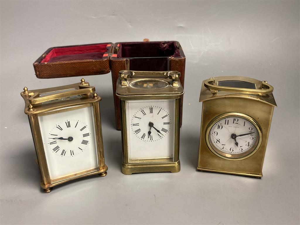 Three small gilt brass carriage timepieces, one with leather outer case, largest 10.5cm high